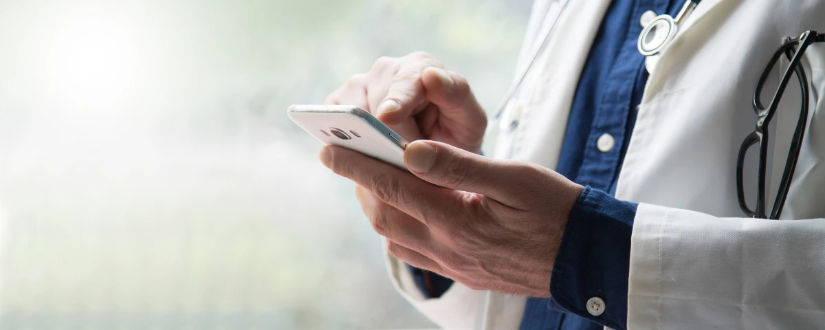 Physician using a mobile phone to prescribe medications